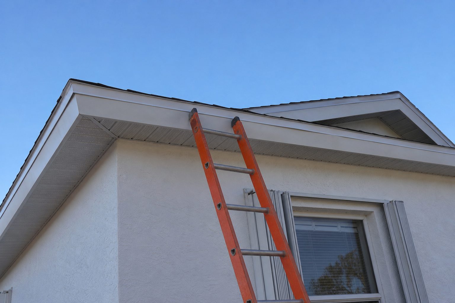 White stucco Florida house with a hip roof, folded window shutters and an orange ladder leaning against the eave